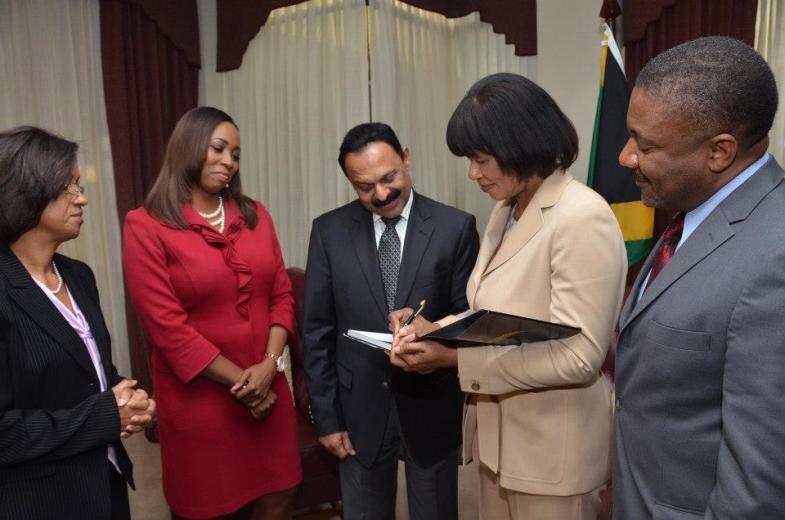 Looking on are: (from left) Mrs. Sancia Bennett –Templer, President of JAMPRO, Ms. Odetta Rockhead, CEO of the local operations of Sutherland Global and the Hon. Phillip Paulwell, Minister of Science, Technology, Energy and Mining.